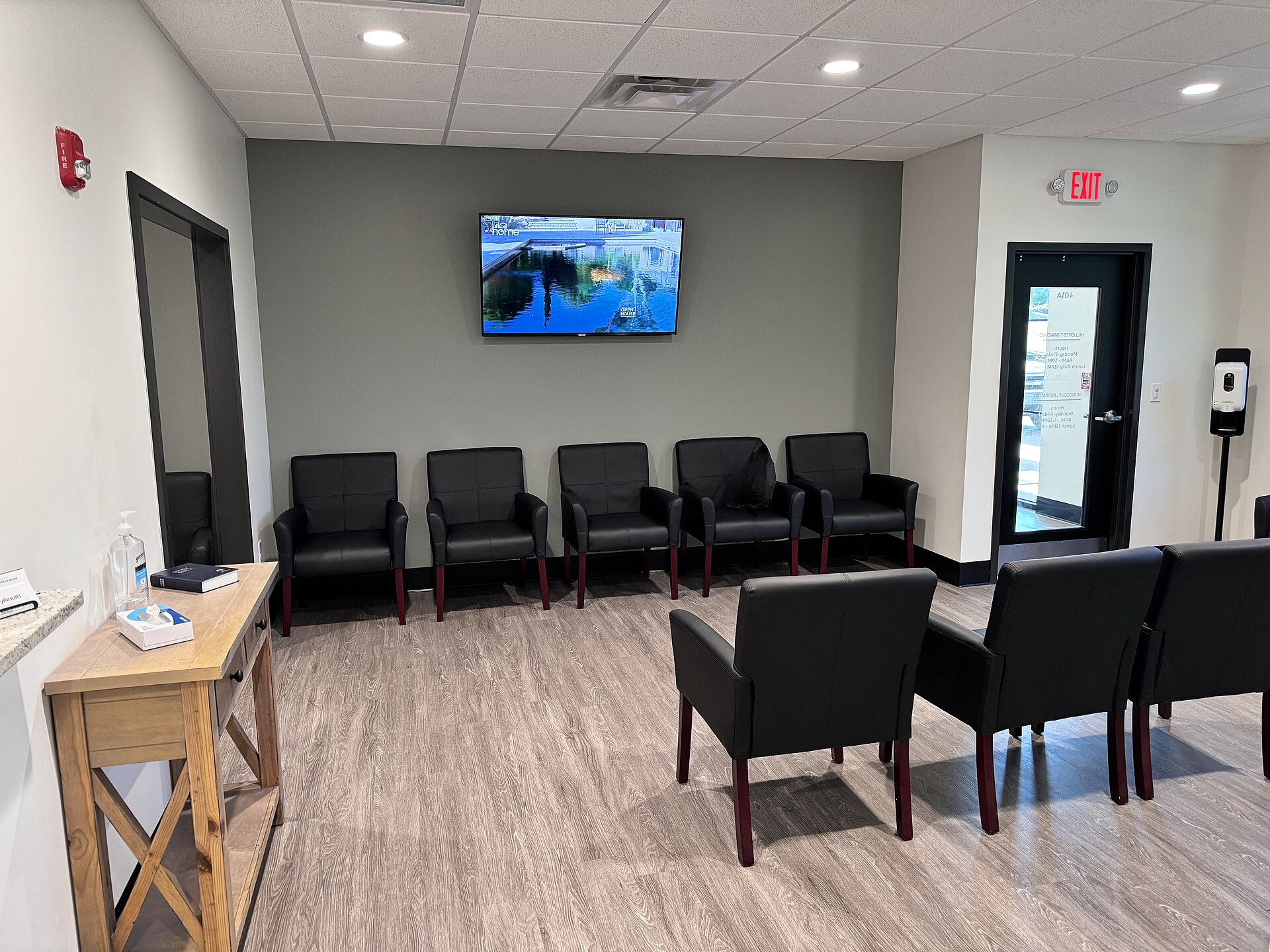 A waiting room with comfortable chairs and a television, reflecting themes of transition and migration.